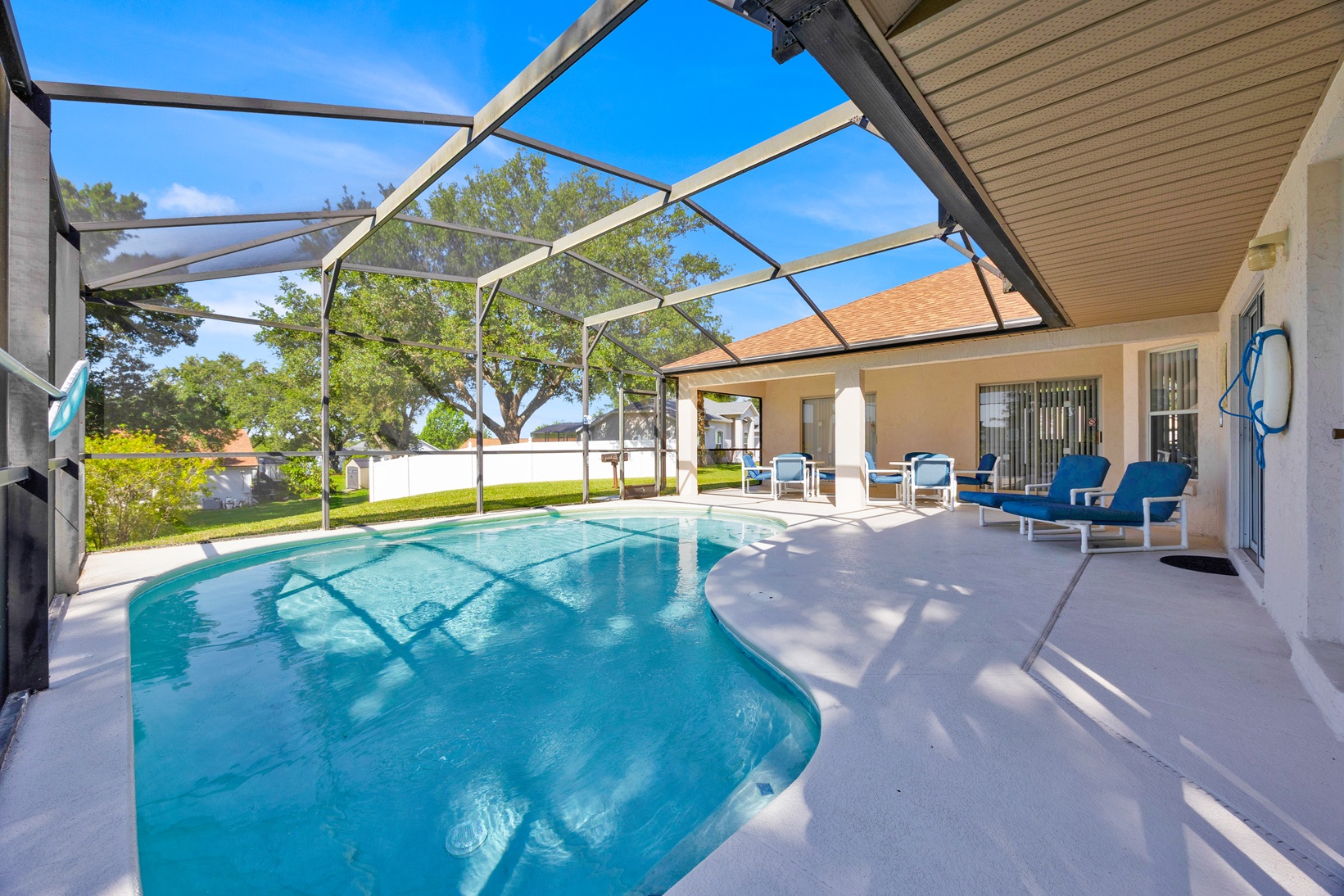 Private swimming pool with safety fence and tropical backdrop